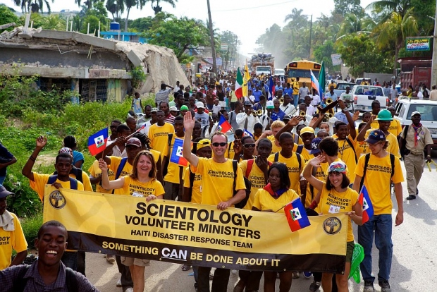 Scientology Frivillige prester fra Haiti og andre land marsjerer fra Port-au-Prince forstaden Carrefour til byen Leogane for å feire «Flag Day», en nasjonal helligdag til minne om Haitis uavhengighet fra den franske undertrykkelsen og slaveri i 1803.